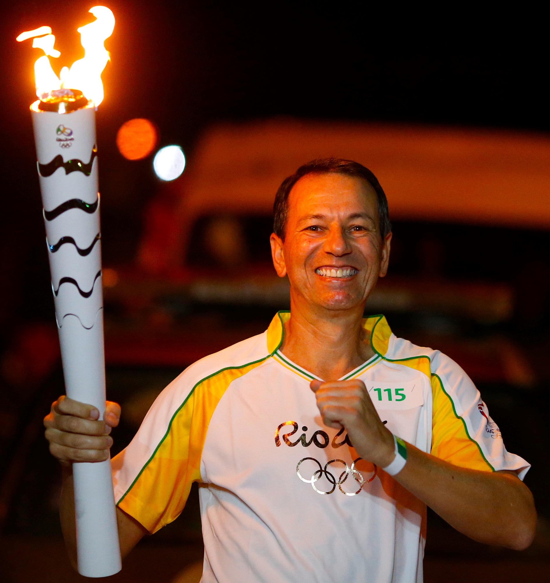 Atleta Olímpico Claudio Bertolino conduzindo a tocha olímpica Rio 2016