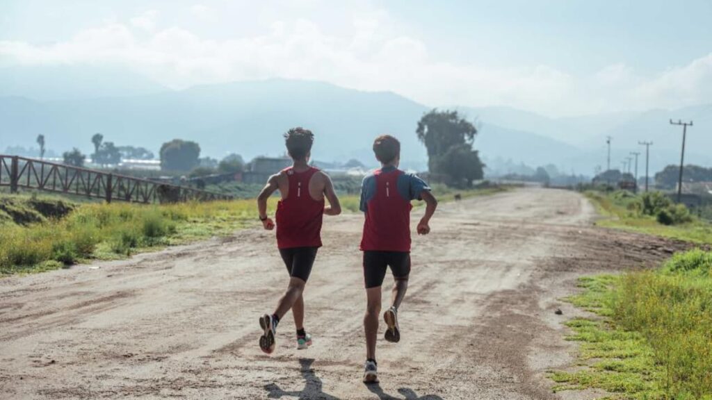 Corredores treinando ao amanhecer, representando o propósito e a jornada na corrida.